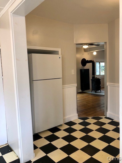 kitchen with white fridge, dark hardwood / wood-style floors, and a wood stove