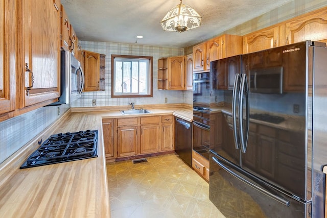 kitchen featuring hanging light fixtures, sink, and black appliances