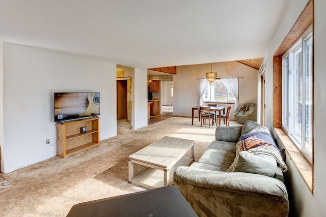 carpeted living room with a chandelier