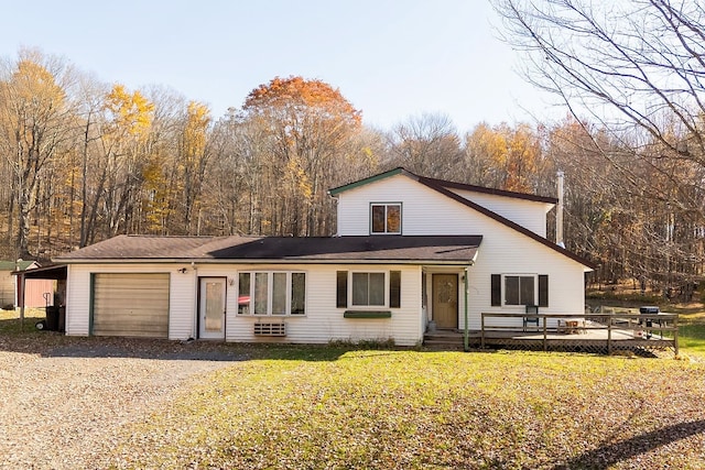 view of front facade with a garage, a wooden deck, and a front yard