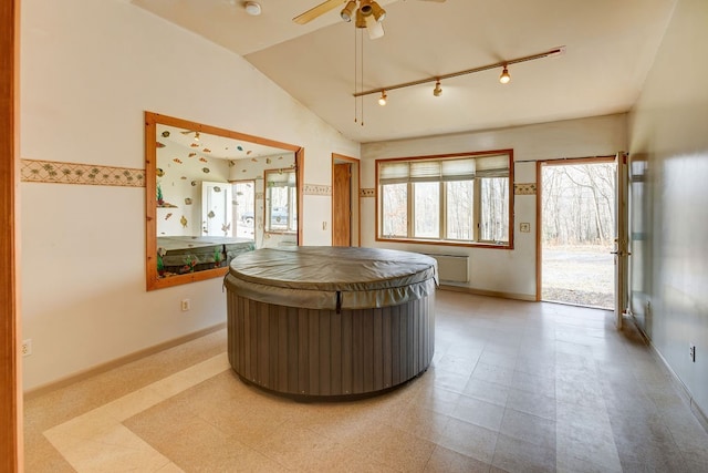 reception area with ceiling fan and a hot tub