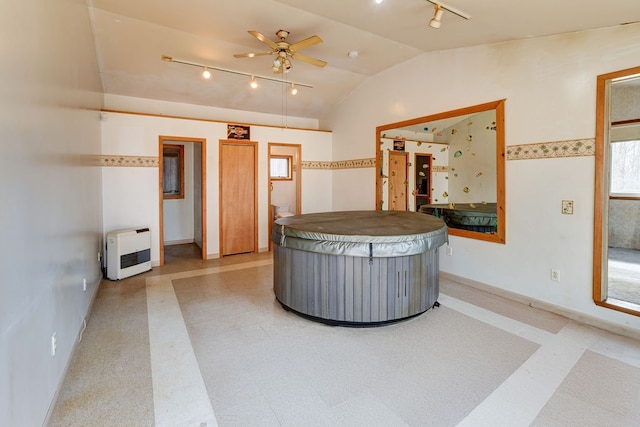 interior space featuring lofted ceiling, track lighting, heating unit, a hot tub, and ceiling fan