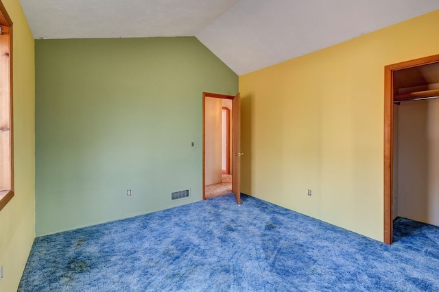 unfurnished bedroom featuring a closet, lofted ceiling, and carpet floors