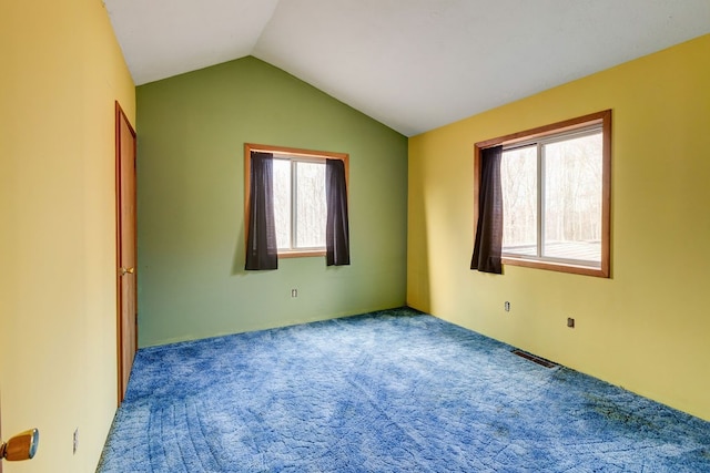 empty room with vaulted ceiling and carpet flooring