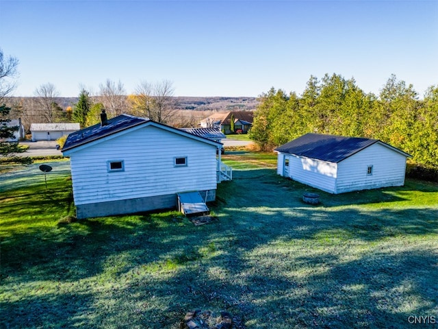 view of side of home with a storage shed and a yard