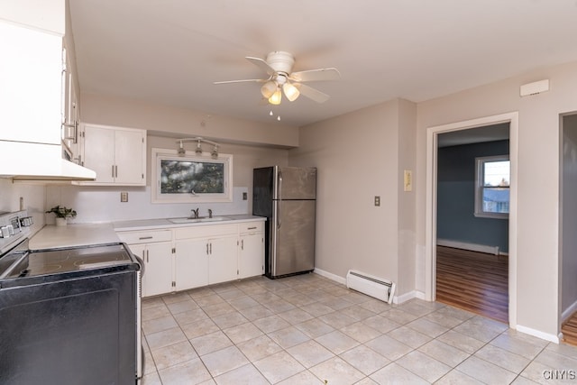 kitchen with sink, appliances with stainless steel finishes, a baseboard heating unit, and white cabinets