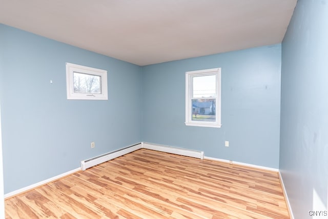 unfurnished room with a baseboard radiator and light hardwood / wood-style flooring