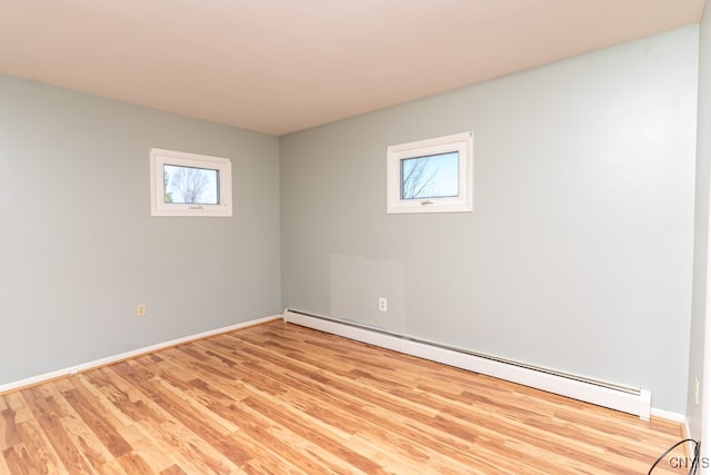 unfurnished room featuring light hardwood / wood-style flooring and a baseboard heating unit