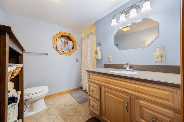 bathroom with toilet, vanity, and tile patterned flooring