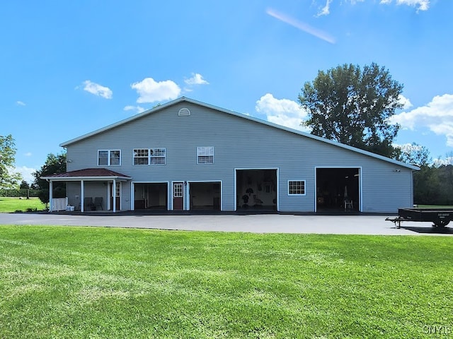 rear view of house featuring a garage and a lawn