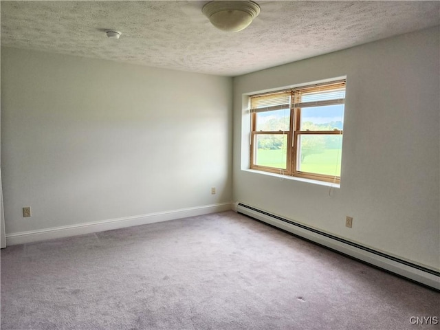 empty room featuring baseboard heating, carpet, and a textured ceiling