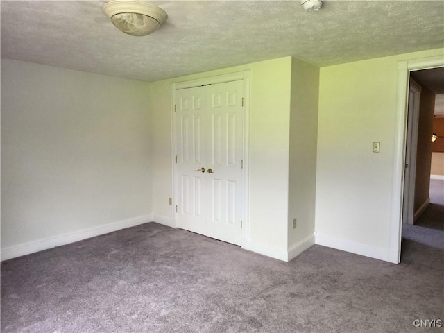 unfurnished bedroom featuring carpet, a textured ceiling, and a closet