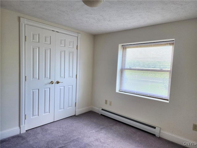 unfurnished bedroom with a textured ceiling, carpet floors, a baseboard radiator, and a closet