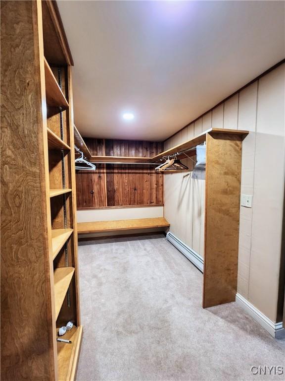 spacious closet featuring light carpet and a baseboard heating unit