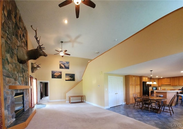 carpeted living room with a fireplace, high vaulted ceiling, and ceiling fan