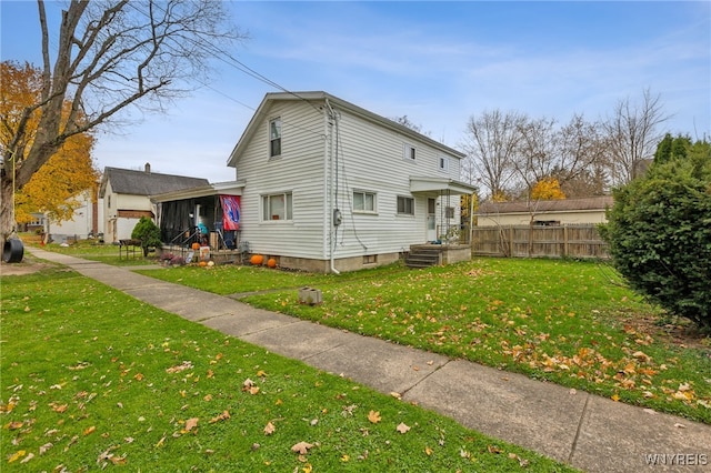 rear view of house featuring a yard