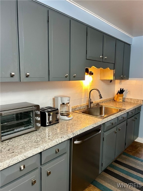 kitchen with backsplash, dark hardwood / wood-style floors, gray cabinets, sink, and stainless steel dishwasher