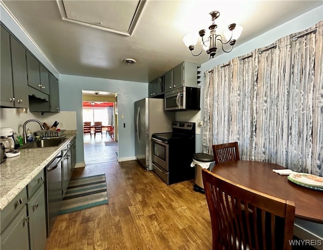 kitchen featuring sink, light hardwood / wood-style flooring, appliances with stainless steel finishes, and a notable chandelier