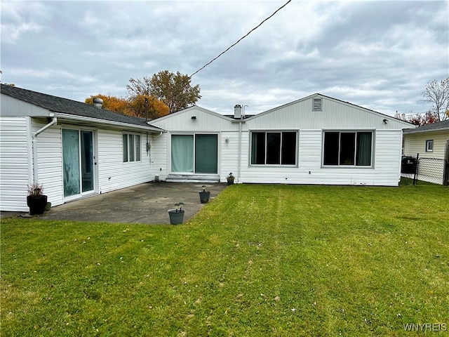 back of house featuring a lawn and a patio