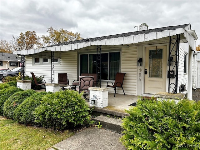 back of property featuring covered porch