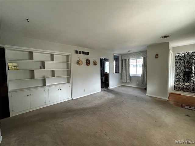 unfurnished living room with light colored carpet