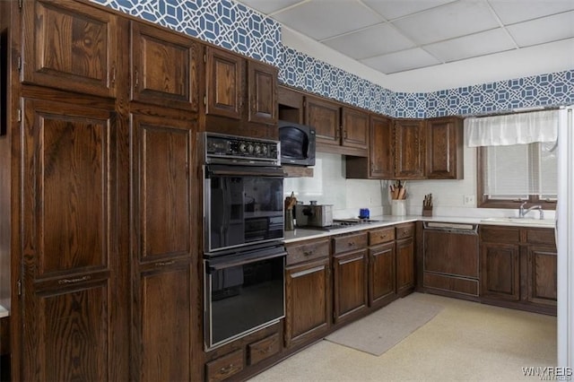 kitchen featuring sink, a drop ceiling, dark brown cabinetry, and stainless steel appliances