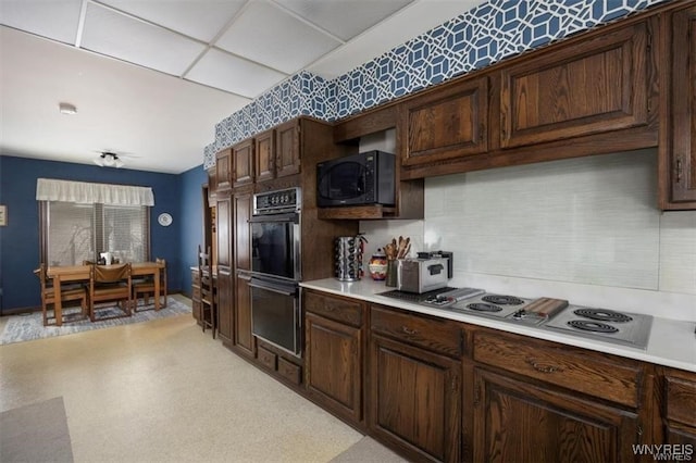 kitchen featuring black appliances, dark brown cabinets, and a paneled ceiling