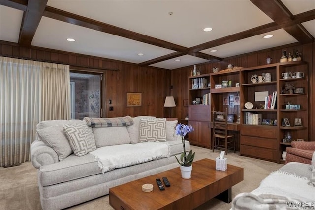 living room with beam ceiling, coffered ceiling, wooden walls, and light colored carpet