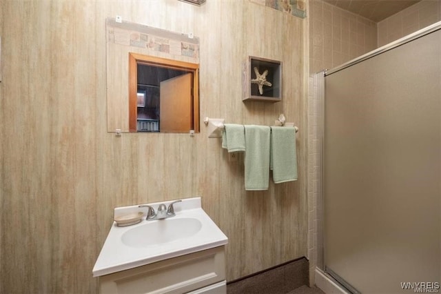 bathroom featuring vanity, an enclosed shower, and wooden walls