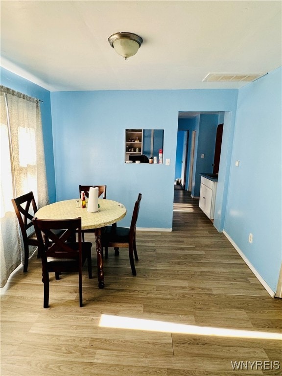 dining space with wood-type flooring