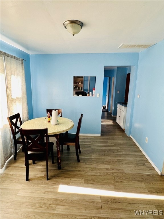 dining space with wood-type flooring