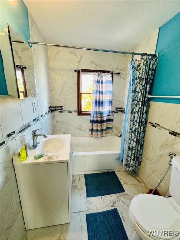 full bathroom with vanity, toilet, shower / bath combo with shower curtain, and tile walls