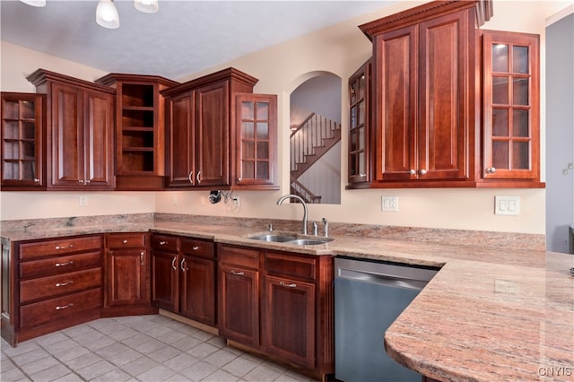 kitchen with sink, dishwasher, light stone countertops, and light tile patterned floors