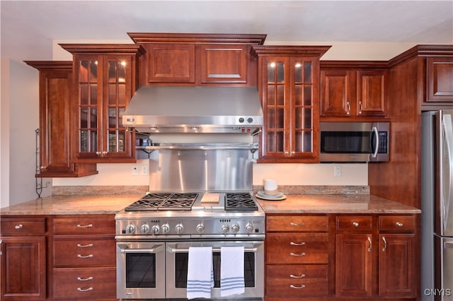 kitchen with appliances with stainless steel finishes and range hood