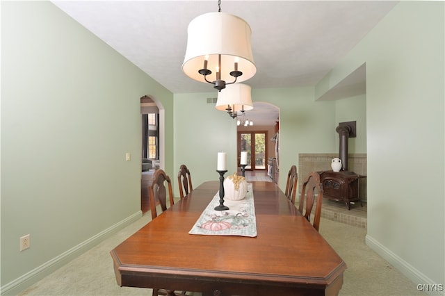 carpeted dining area with a wood stove and french doors