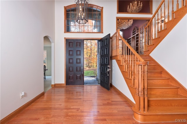 foyer with a notable chandelier, hardwood / wood-style flooring, and a high ceiling