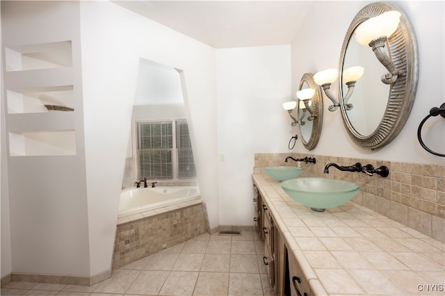 bathroom with vanity, tiled bath, and tile patterned flooring