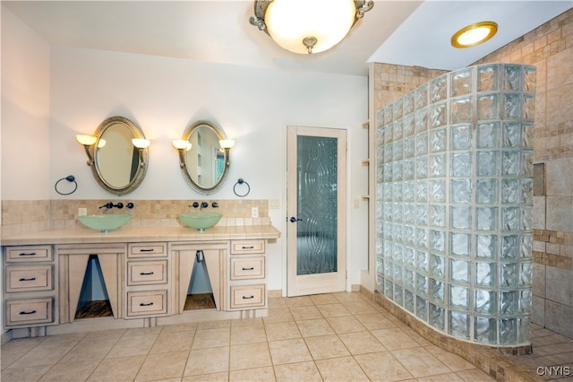 bathroom featuring vanity, a tile shower, and tile patterned floors