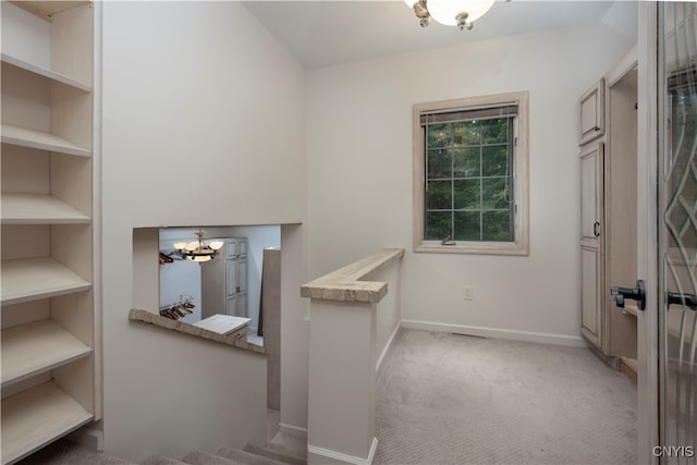 walk in closet featuring light carpet and a notable chandelier