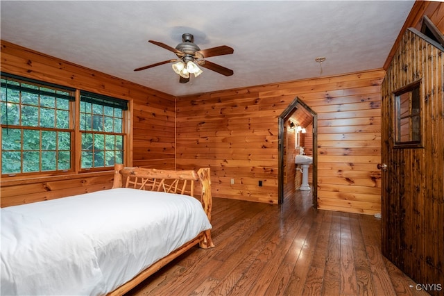 unfurnished bedroom featuring ceiling fan, wood walls, and dark hardwood / wood-style flooring