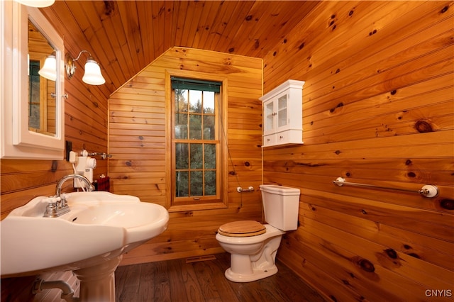 bathroom featuring toilet, wood walls, and vaulted ceiling