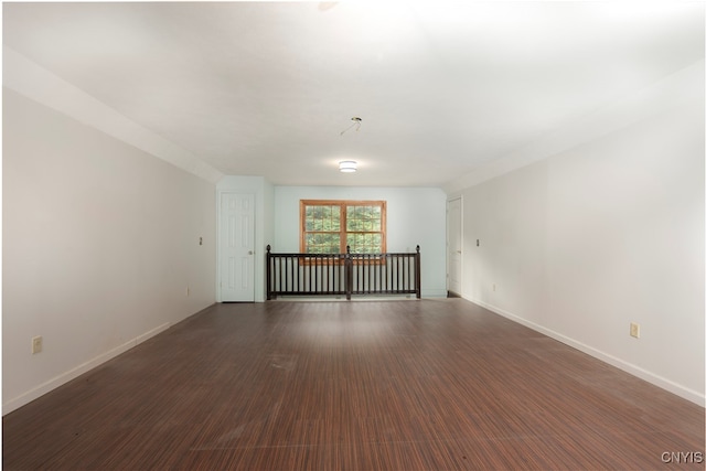 empty room with dark hardwood / wood-style flooring