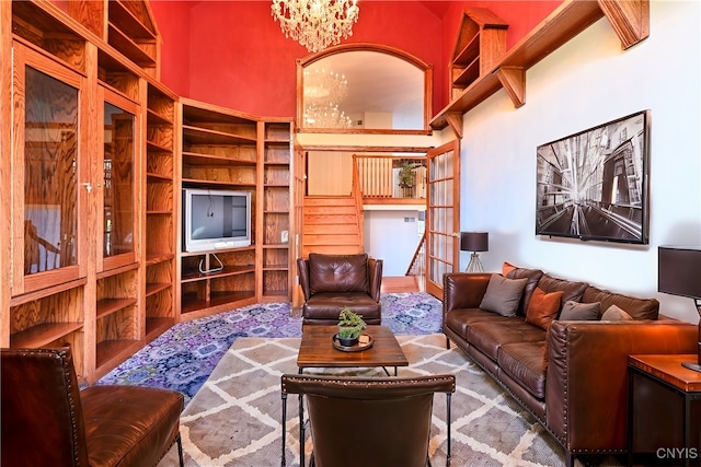 living room with a towering ceiling and a chandelier