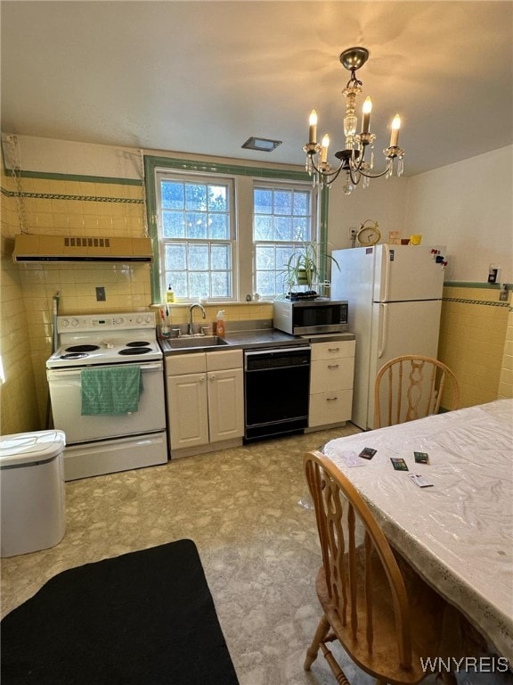 kitchen with white cabinetry, pendant lighting, an inviting chandelier, sink, and white appliances