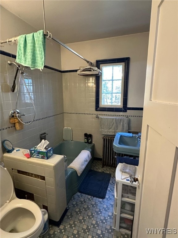 bathroom featuring radiator heating unit, tile walls, tiled shower / bath combo, tile patterned flooring, and toilet