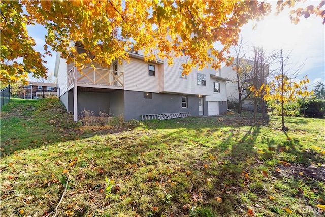 back of house featuring a garage and a yard