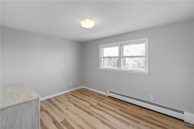 spare room with a baseboard radiator and light hardwood / wood-style floors