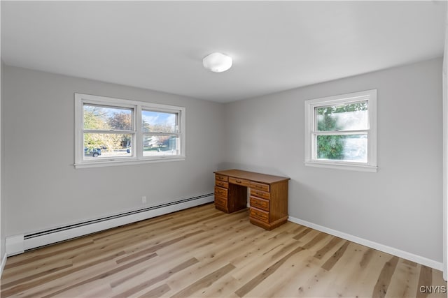 spare room featuring light wood-type flooring and a baseboard heating unit