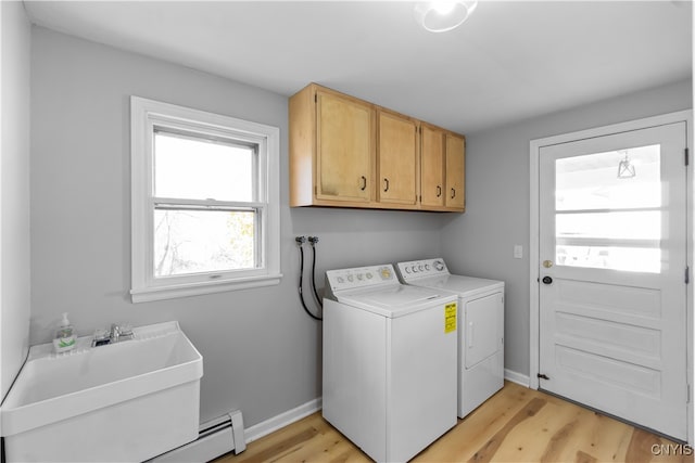 laundry area with cabinets, light hardwood / wood-style flooring, and washer and clothes dryer