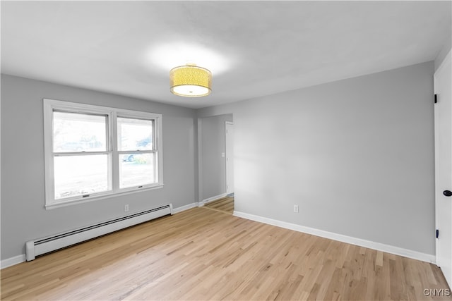 empty room featuring light wood-type flooring and a baseboard radiator